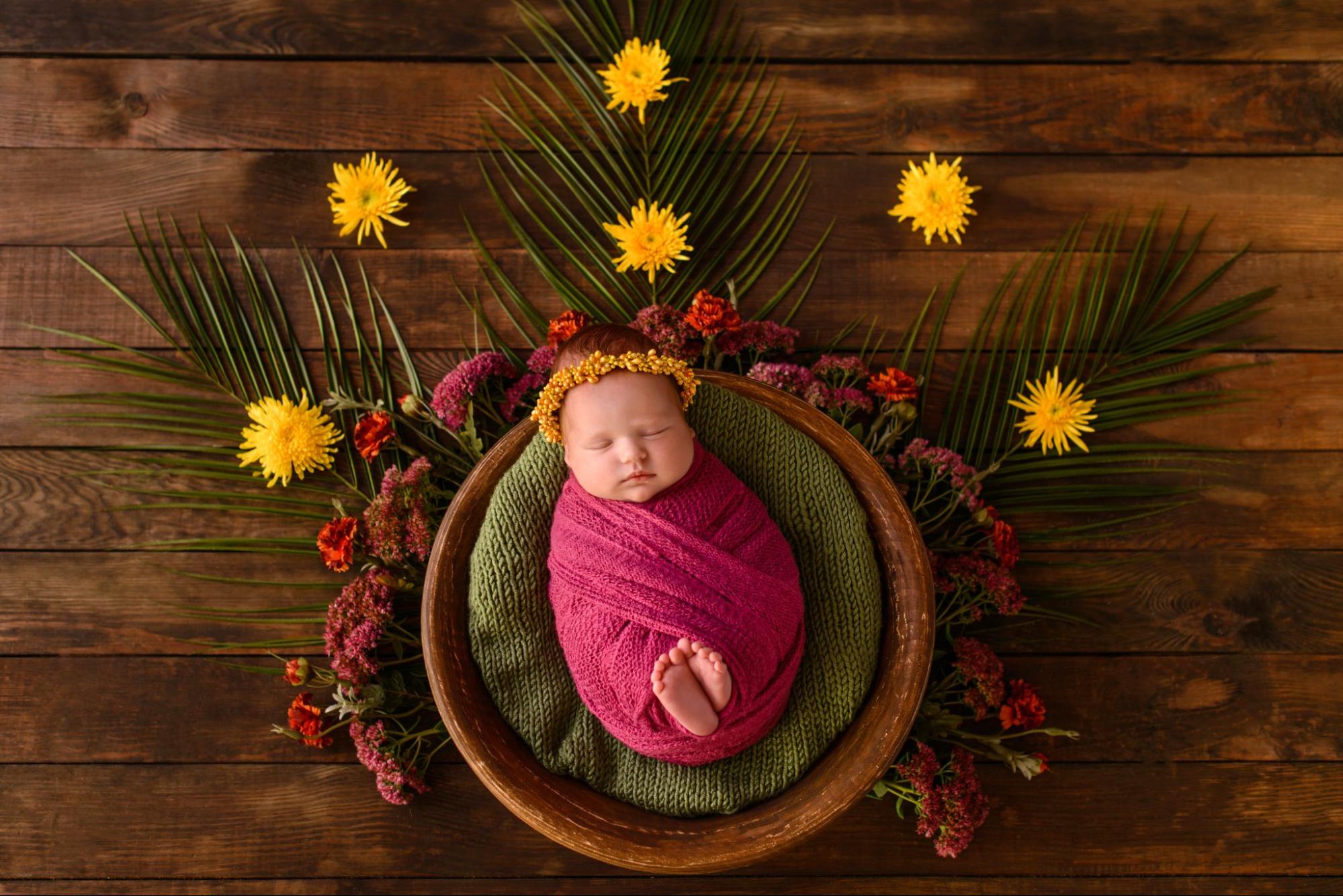 Baby girl in floral dress, blooming garden backdrop, capturing innocence and joy.