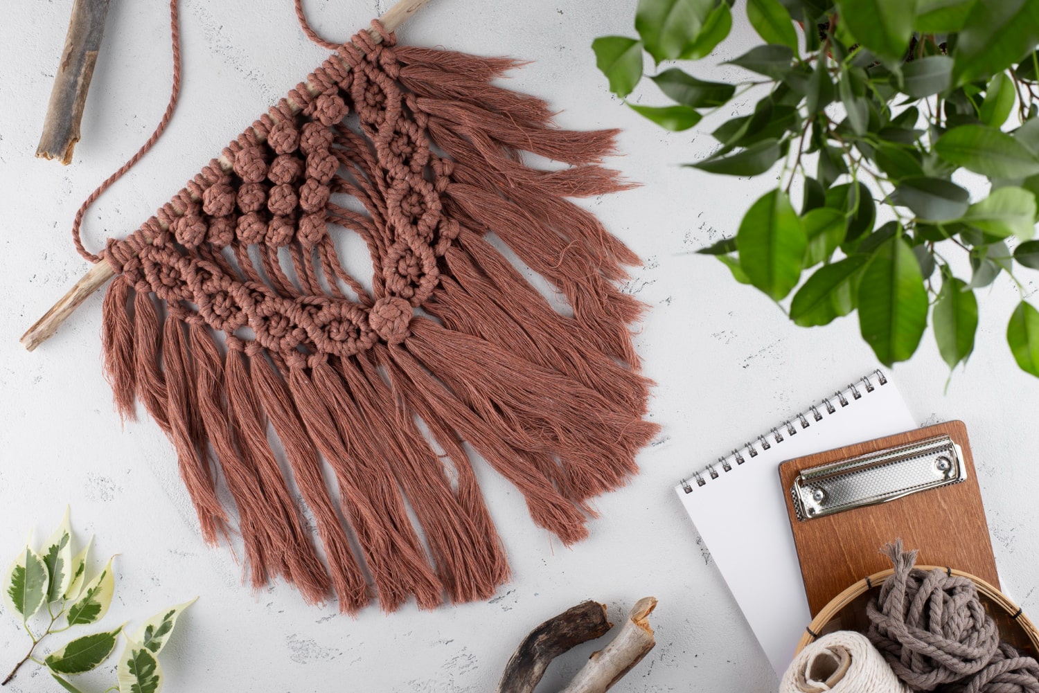 A stylish macrame wall hanging adorned with lush plants, adding a touch of nature to your home decor.