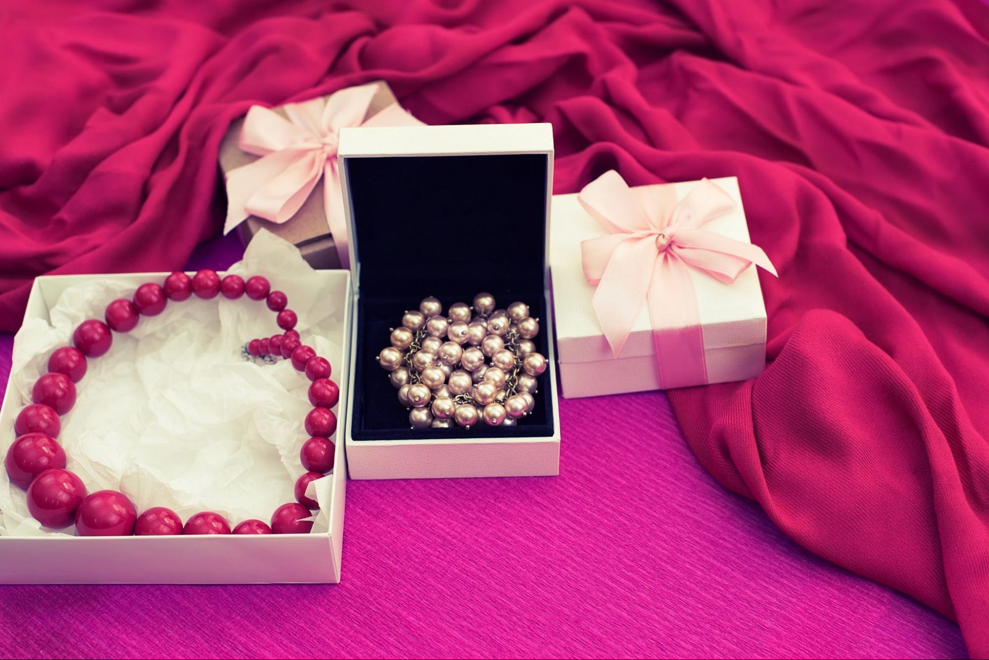 Customized Jewelry Birthday Gift: A box with a necklace and another necklace on a red cloth