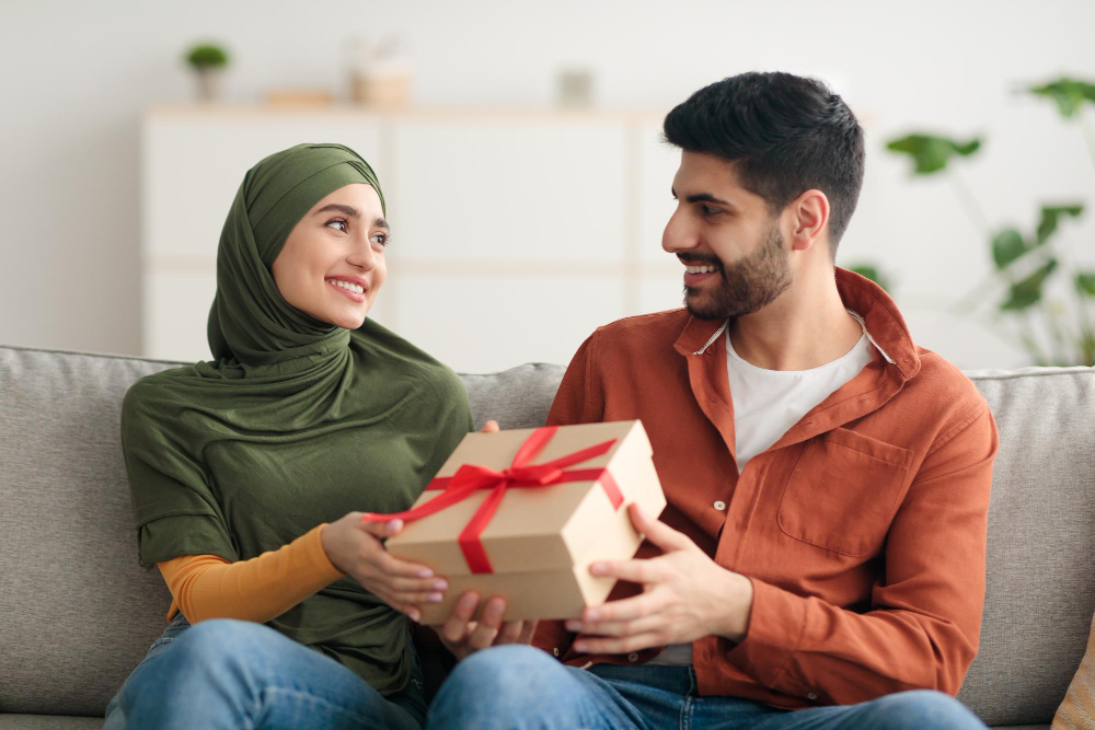 A joyful Muslim couple exchanging birthday gifts on their special day