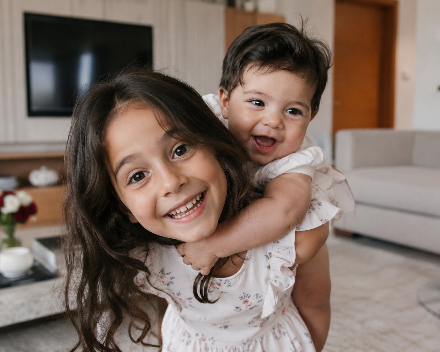 Baby and older sibling sharing a hug during a family photoshoot