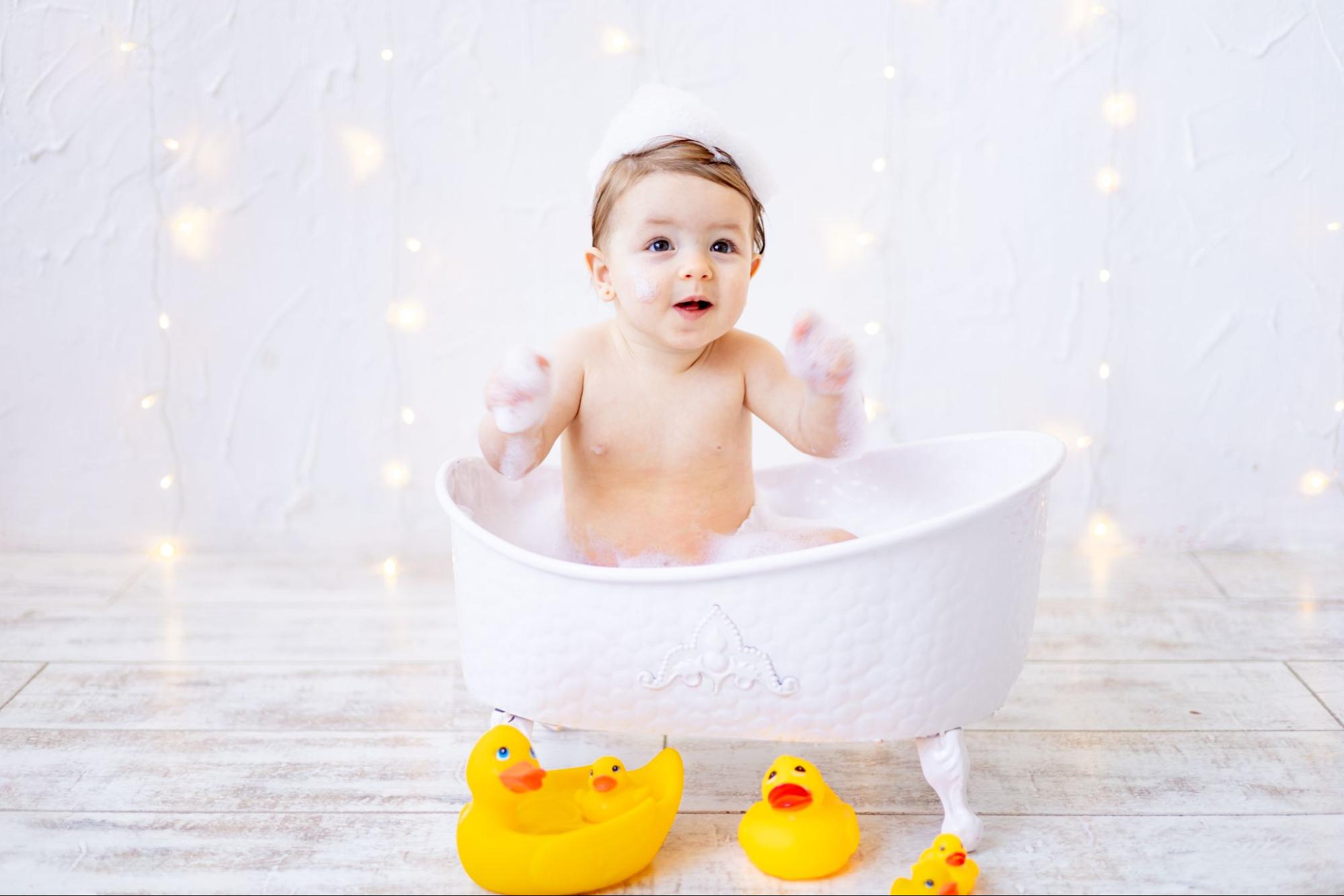 Baby enjoying a bubble bath photoshoot with natural window light
