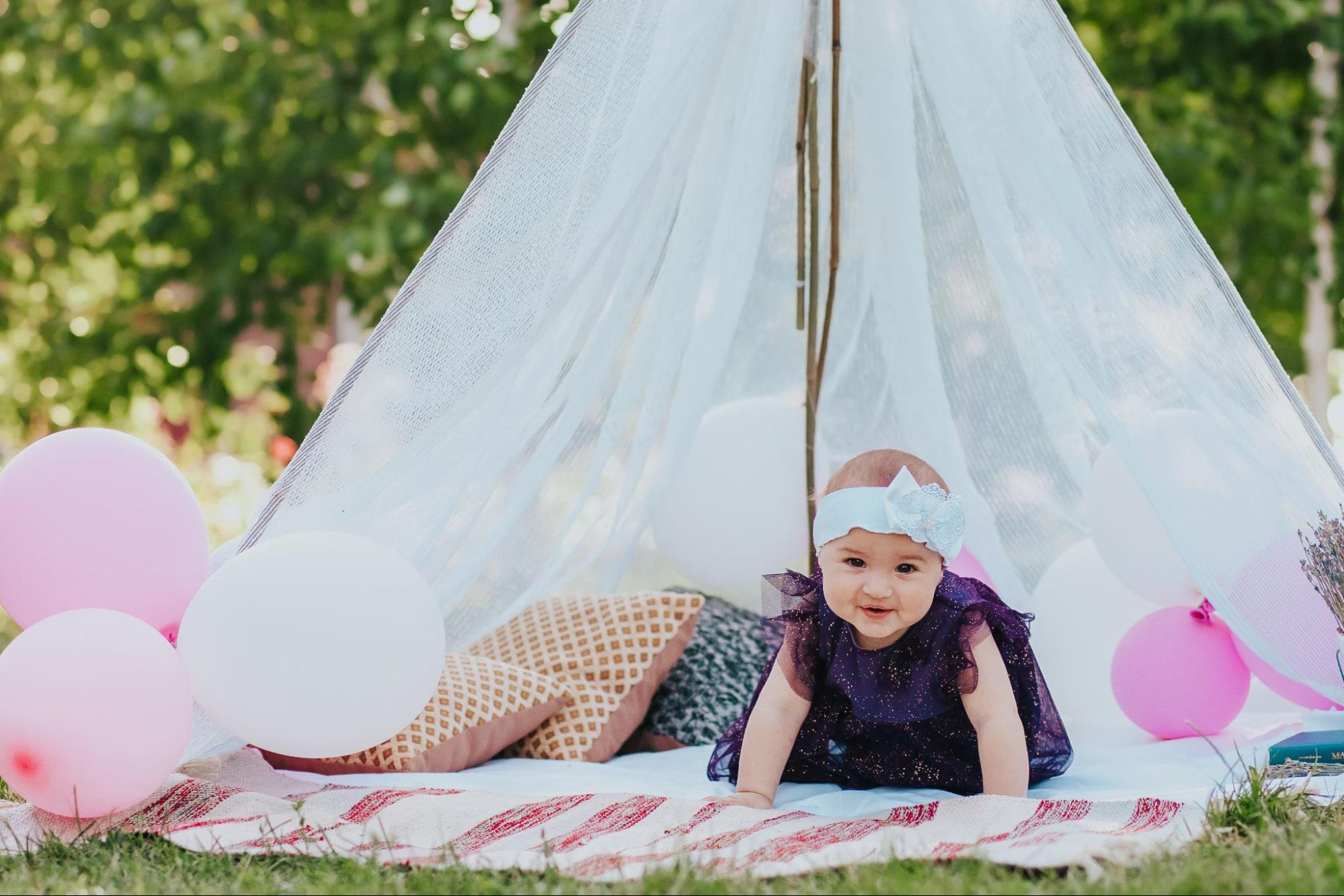 Baby exploring a cozy tent during an outdoor photoshoot